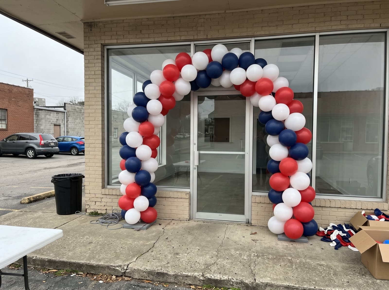 Large balloon arch over a small shop entrance