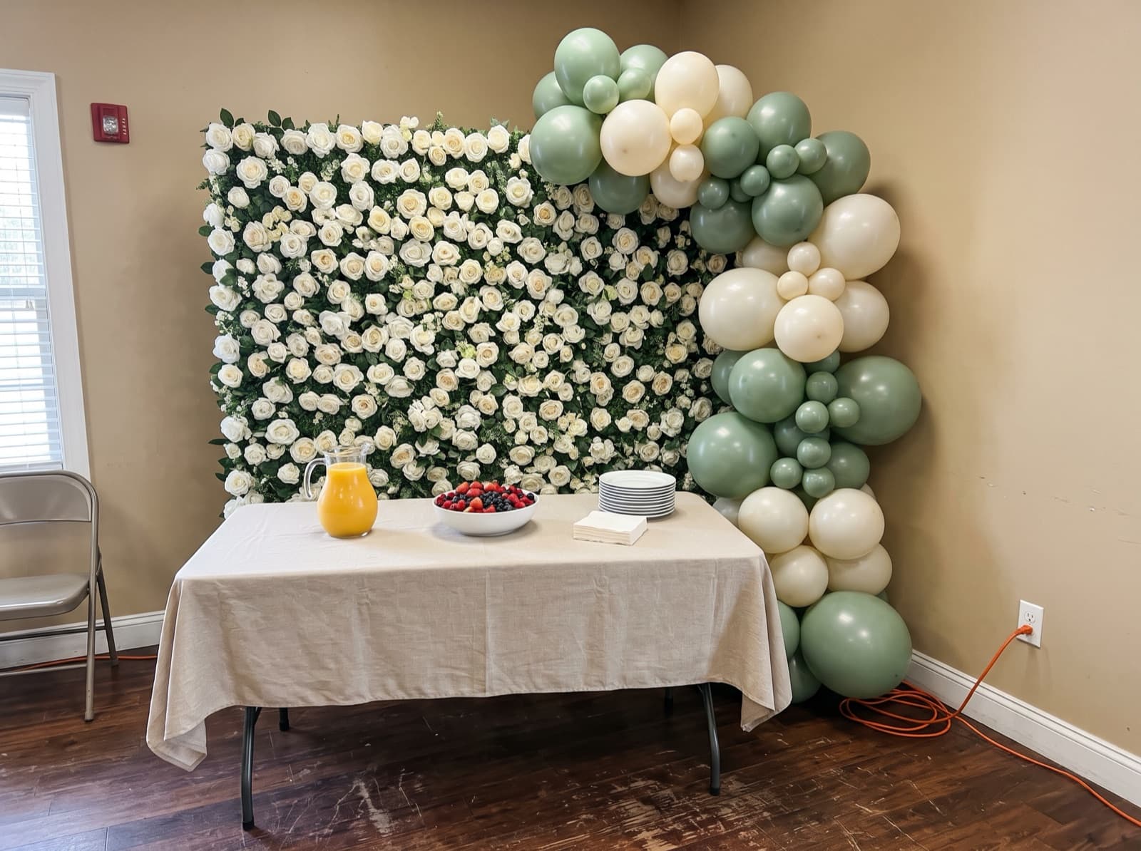 White flower wall backdrop with a sage and ivory balloon garland
