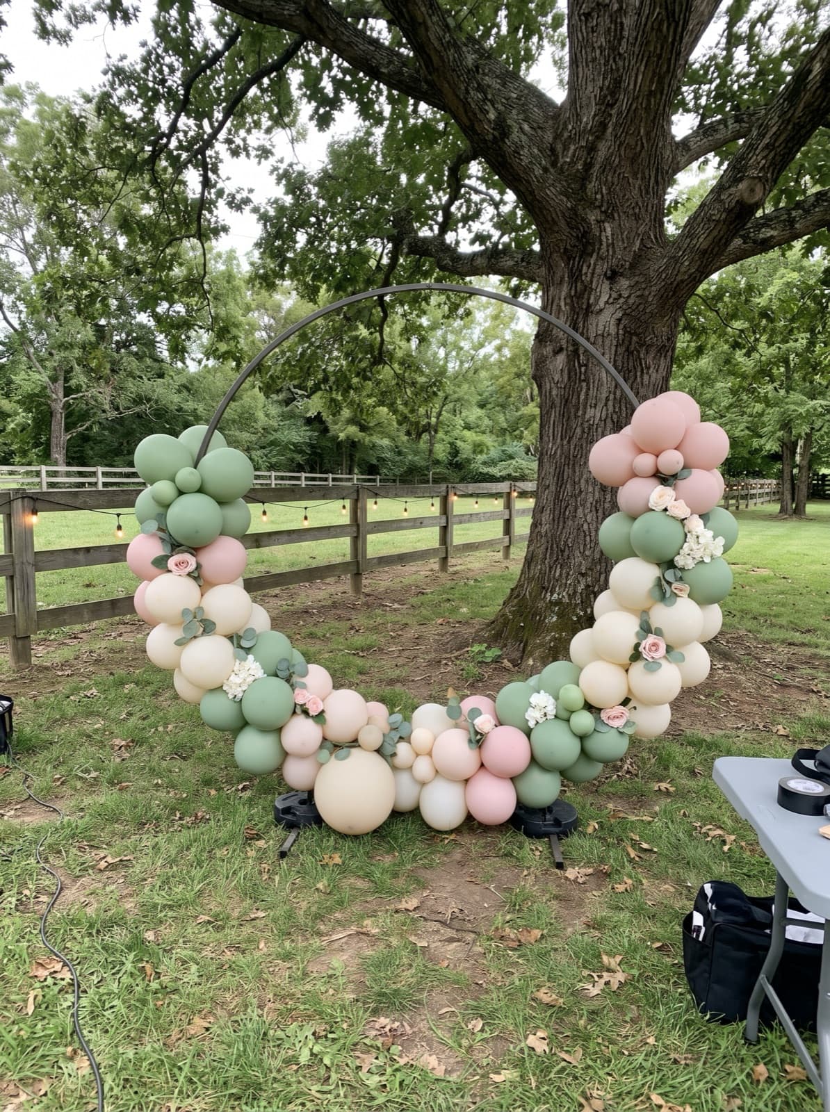 Balloon hoop backdrop with florals on a farm lawn