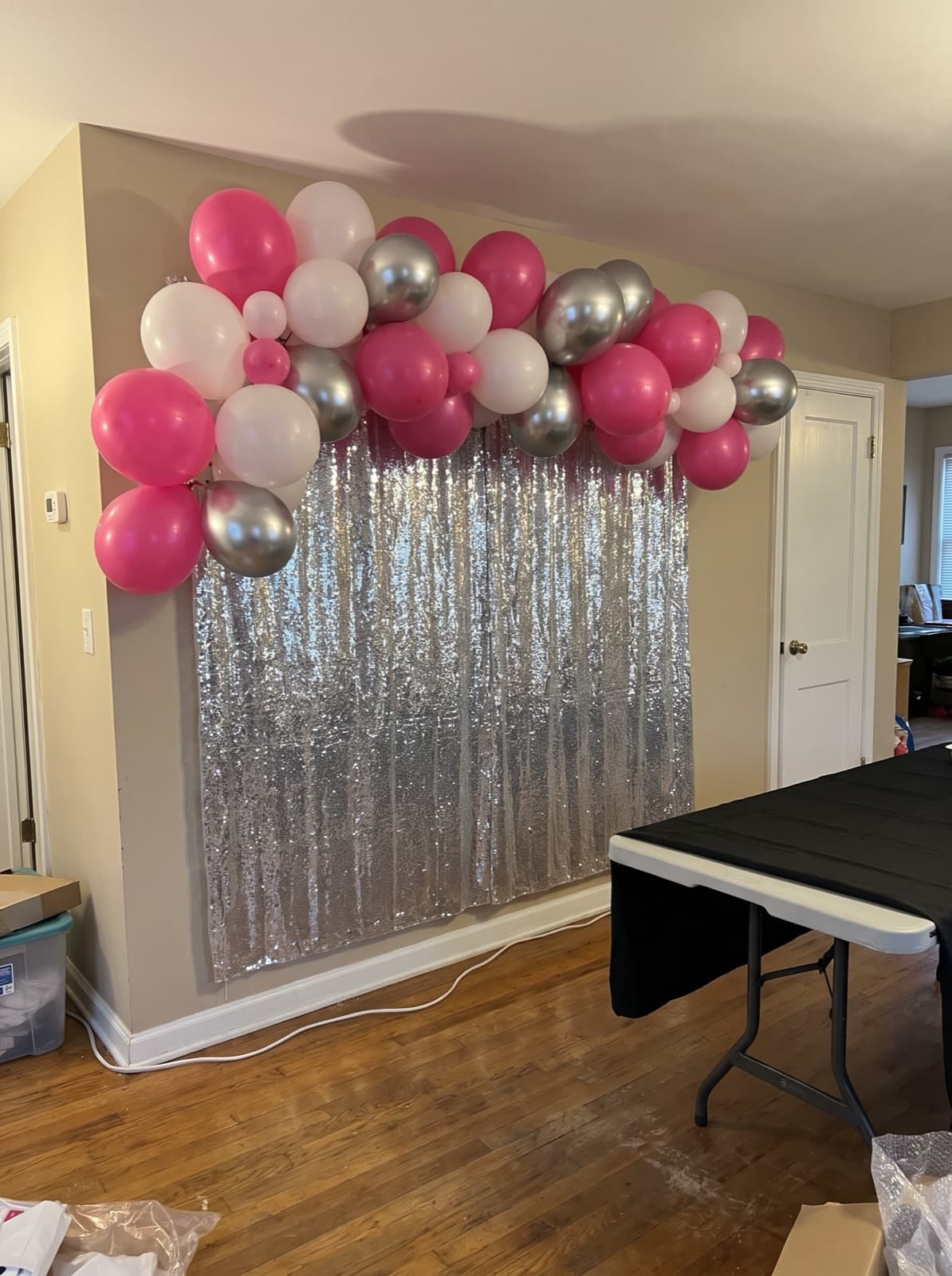 Silver shimmer wall backdrop with a pink balloon garland