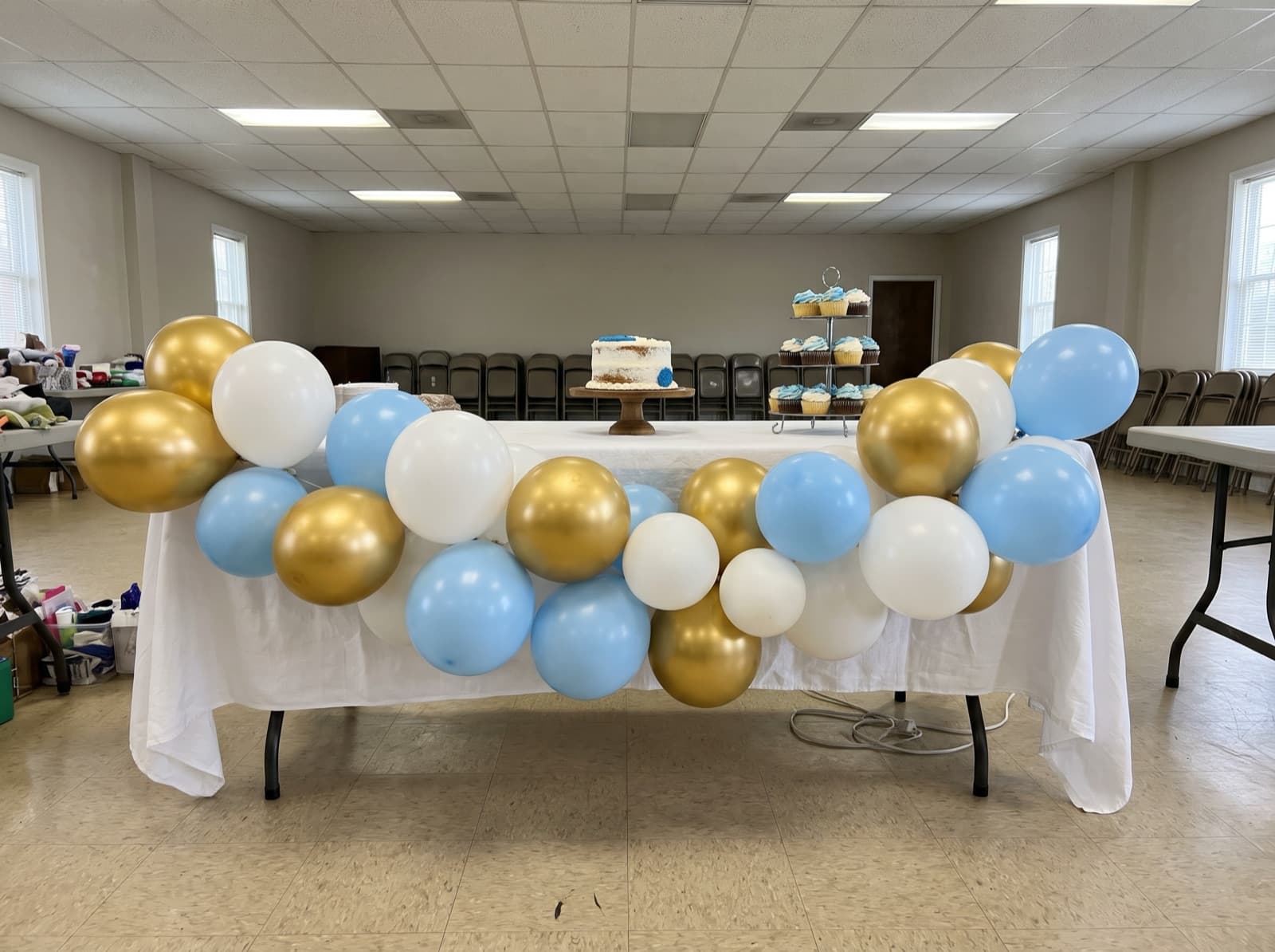 Balloon garland across the front of a first-birthday cake table
