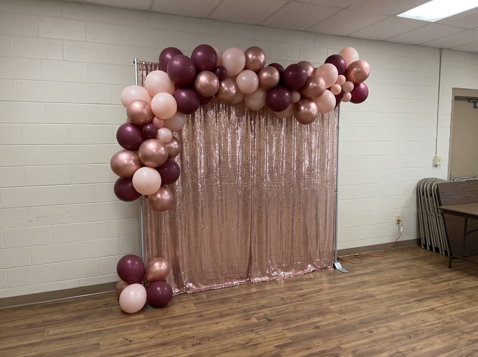 Balloon garland over a rose gold shimmer wall