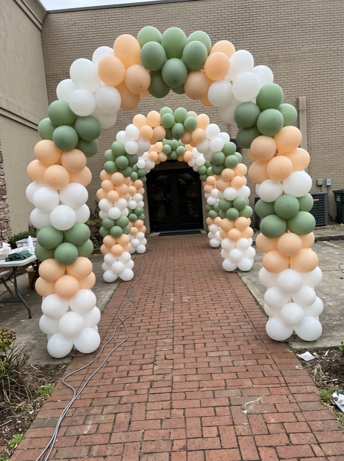 Balloon tunnel of linked arches over a brick walkway