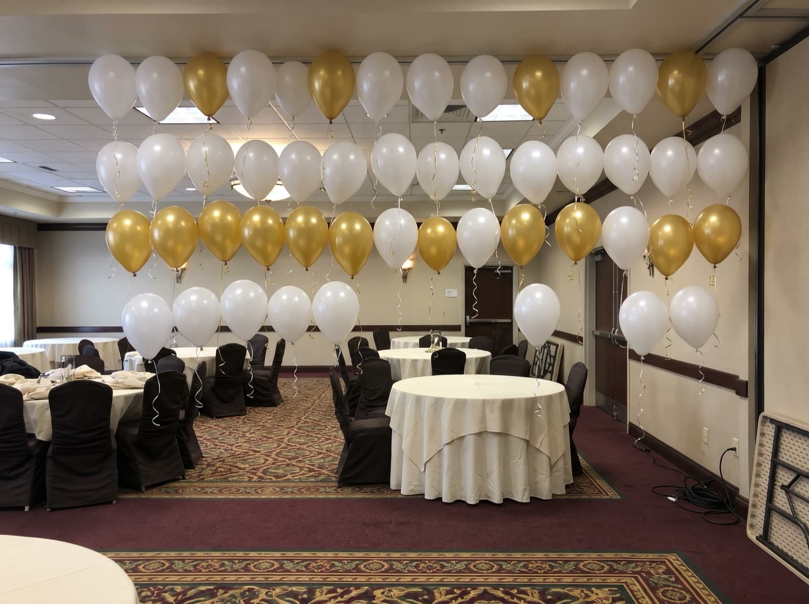 Floating helium balloon wall with ribbons in a hotel ballroom