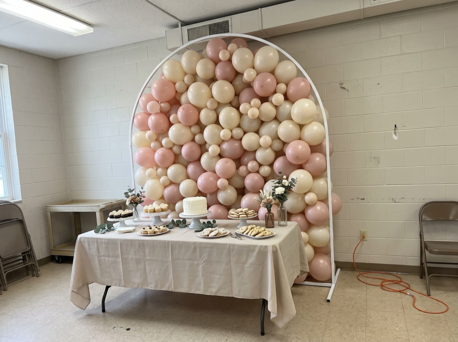 Arched frame filled with blush and ivory balloons